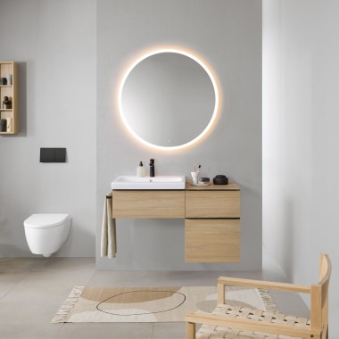Bathroom with grey walls, Geberit bathroom furniture in wood and a round Geberit Option illuminated mirror