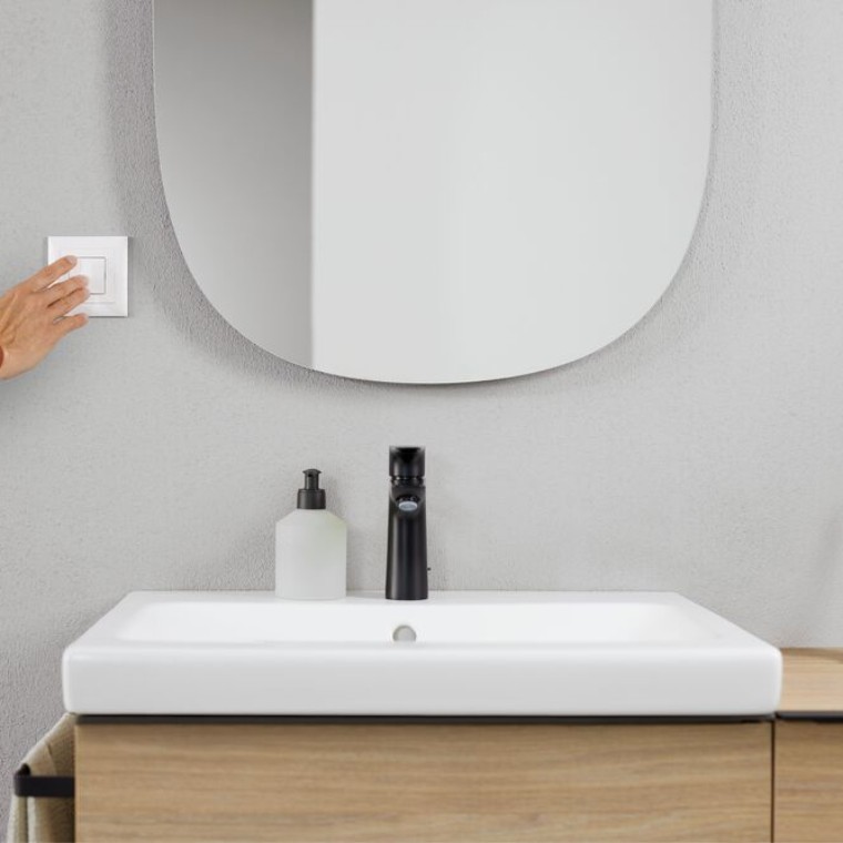 Hand activating light switch in the bathroom (© Geberit)