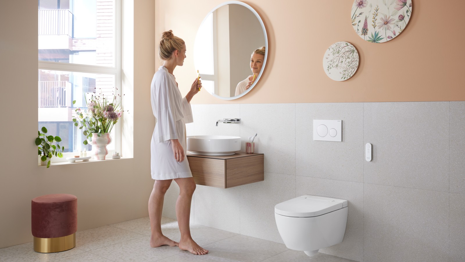 Woman in bathroom with Geberit AquaClean Alba – a cost-effective bidet toilet with spray functionality Woman in bathroom with Geberit AquaClean Alba – a cost-effective bidet toilet with spray functionality