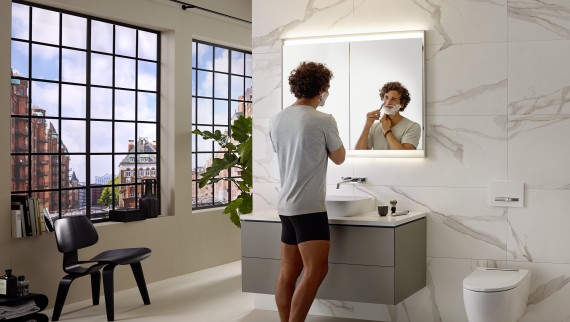 Man shaving at washbasin with Geberit ONE furniture and mirror cabinet