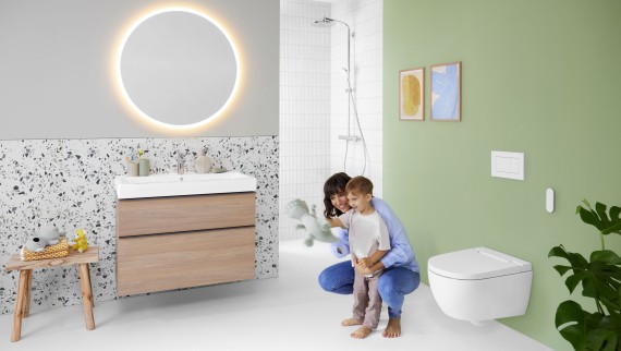 Geberit AquaClean Alba with woman and child in the bathroom Geberit AquaClean Alba with woman and child in the bathroom