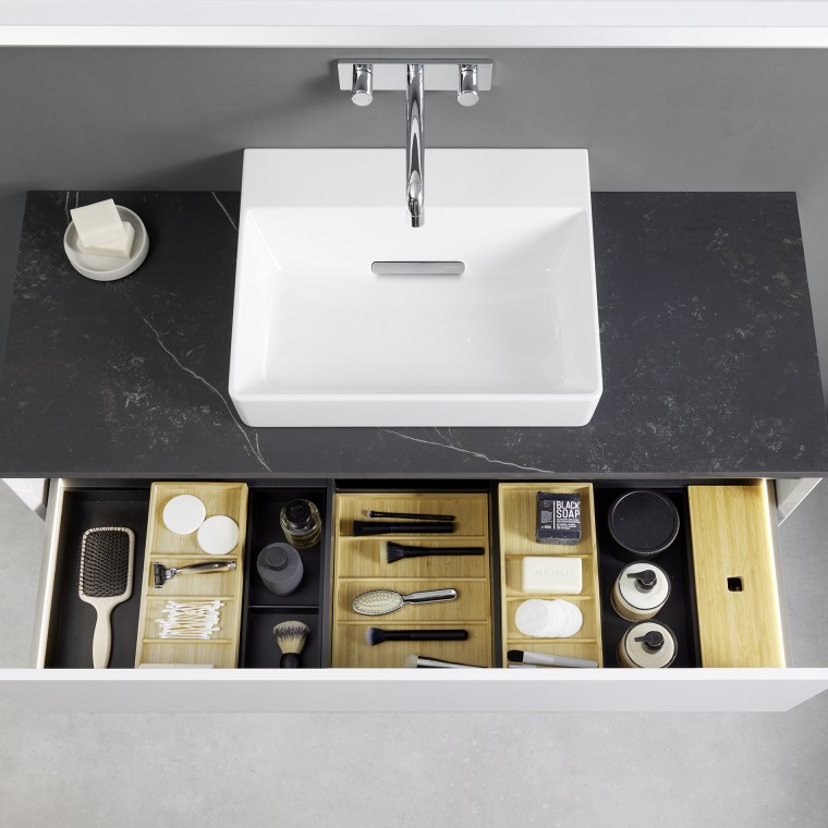 View from above into an open Geberit ONE washbasin drawer with organiser boxes