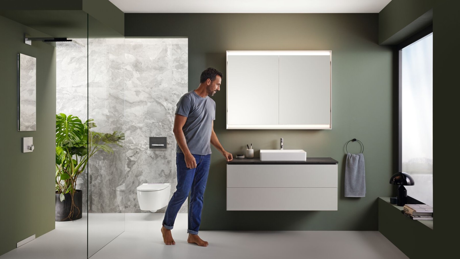 Man in a Geberit bathroom with a walk-in shower Man in a Geberit bathroom with a walk-in shower